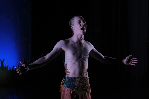 Solo performer singing under blue stage light