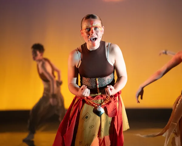 Performer singing beneath warm stage lighting