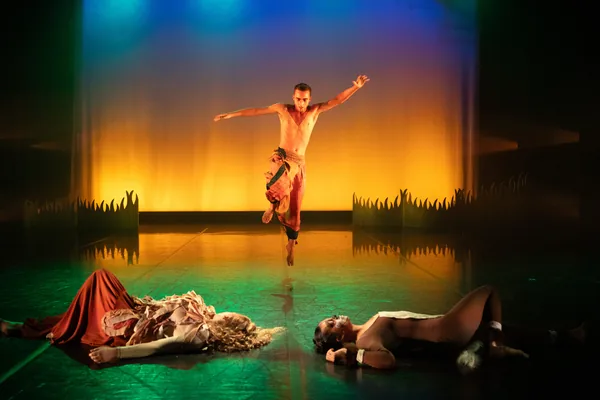 Performers arranged in a dramatic stage tableau