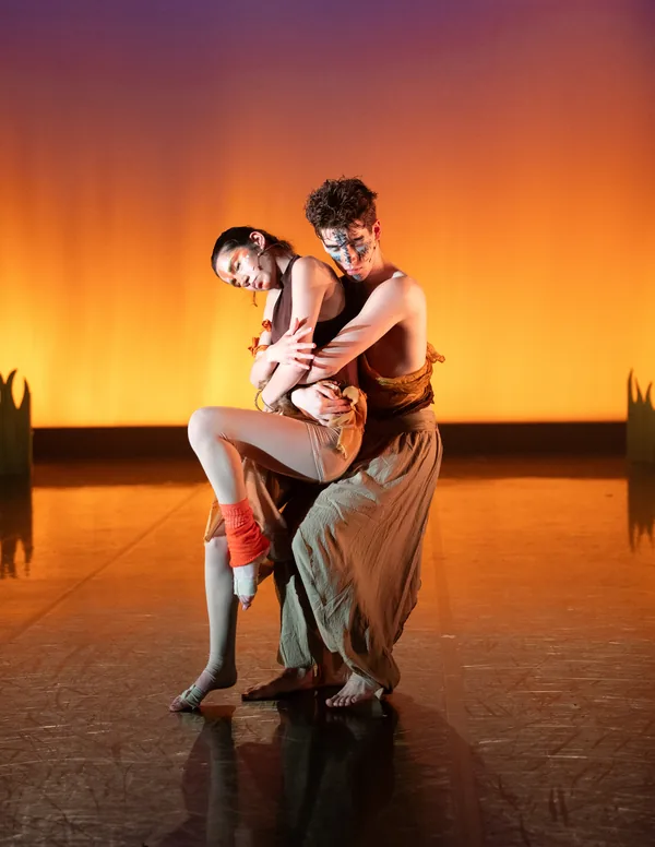 Two performers holding a close pose on stage