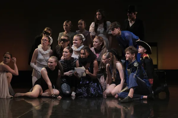 Costumed cast gathered together on stage
