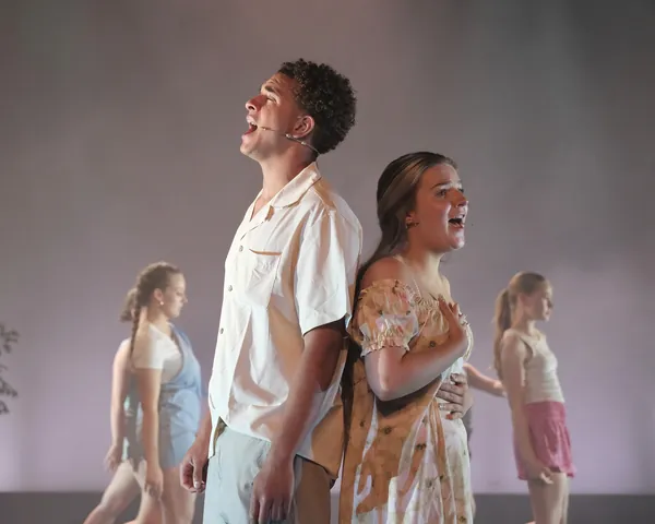 Two performers singing a duet on stage