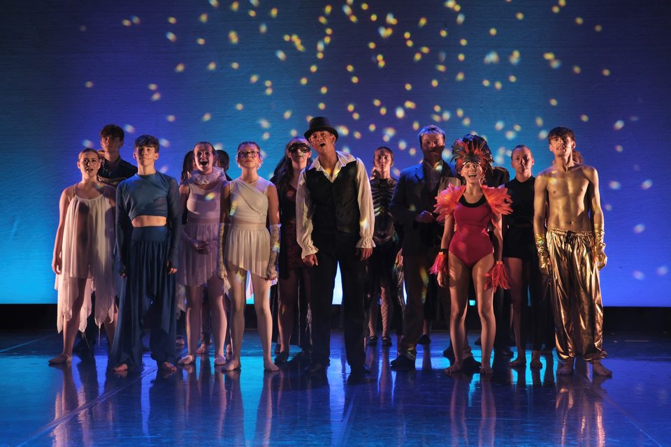 Vibe performers taking a bow beneath stage lights